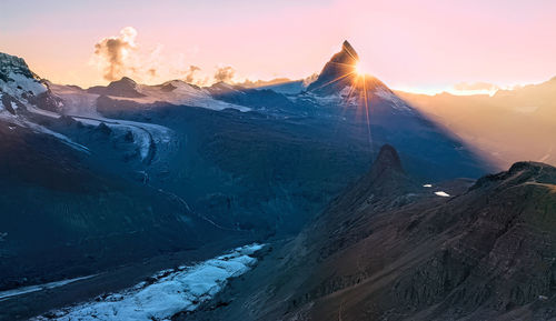 Scenic view of snowcapped mountains against sky during sunset