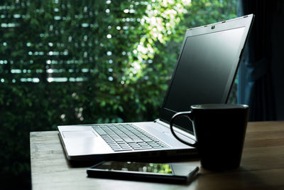 Close-up of laptop and coffee mug on table