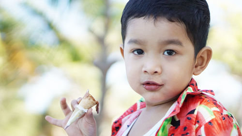 Close-up portrait of cute boy eating food