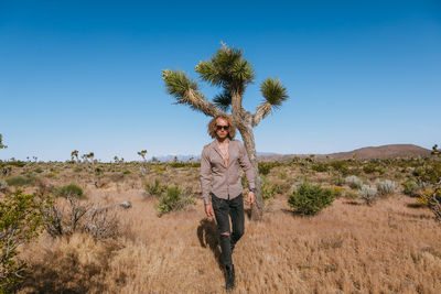 Full length of man standing on landscape against clear sky