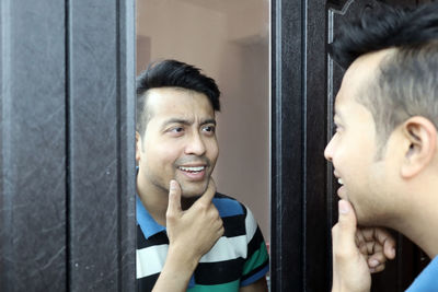 Portrait of smiling young man with reflection