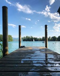 Wooden pier over lake against sky