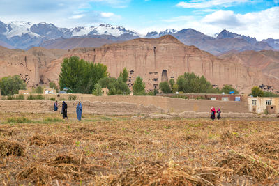 Group of people on field against mountain range in bamyan province of afghanistan 