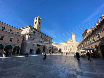 People in historic building against blue sky