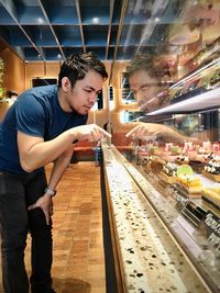 Side view of a young man looking at cakes