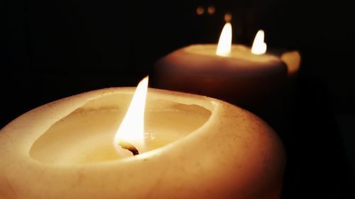 Close-up of lit candle in dark room