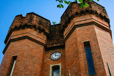 Low angle view of clock tower against blue sky