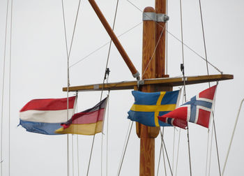 Low angle view of flags hanging against sky