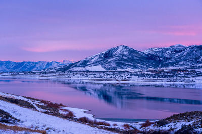 Scenic view of sunrise on snowcapped mountains against sky during winter