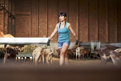 Full length portrait of young woman standing in farm