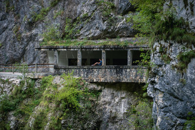 Man sitting on retaining wall of tunnel