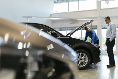 Salesman advising customer in car dealership