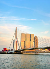 Suspension bridge over river against sky