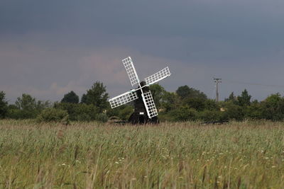 Traditional windmill on field against sky