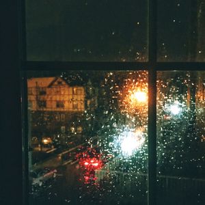 Raindrops on glass window at night