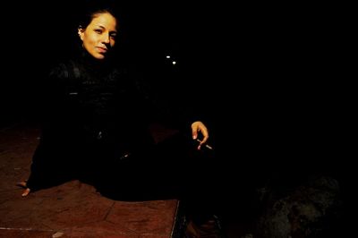 Young woman against black background