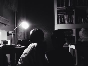 Rear view of woman sitting in the dark