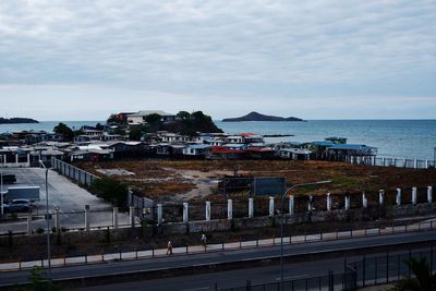 High angle view of buildings by sea against sky