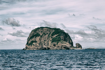 Scenic view of rock formation in sea against sky