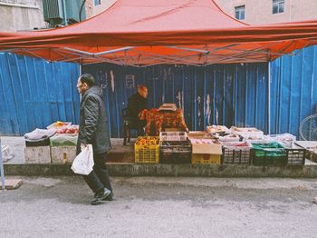 Rear view of man working at market stall in city