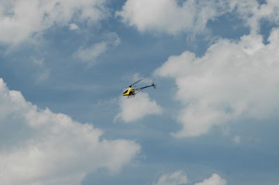 Low angle view of helicopter flying against sky