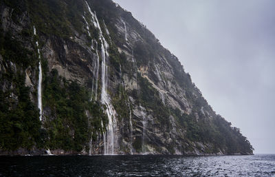 Waterfalls on mountain by sea at te anau