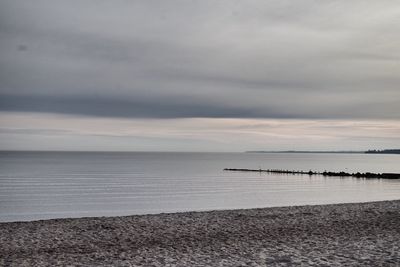 Scenic view of calm sea against cloudy sky