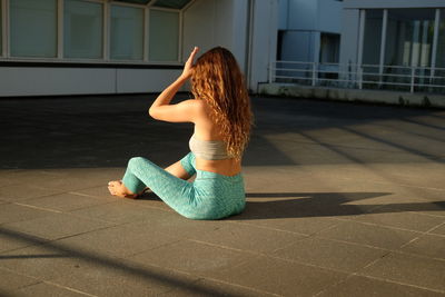 Young woman sitting outdoors on paving stone