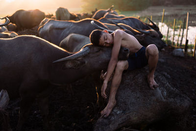 Full length of shirtless man lying in mud