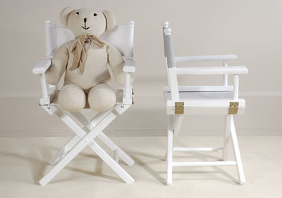 Stuffed toy on table against wall