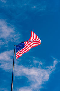 Low angle view of flag against blue sky