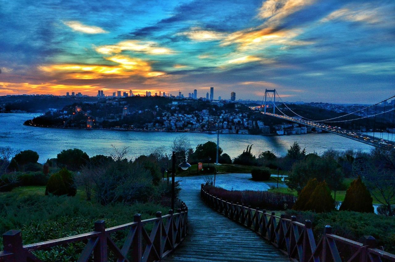 sky, built structure, architecture, water, cloud - sky, the way forward, river, bridge - man made structure, connection, railing, sunset, building exterior, cloud, transportation, cloudy, city, pier, dusk, sea, diminishing perspective