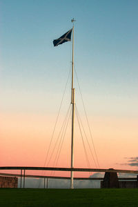 Low angle view of scottish flag against sky during sunset