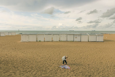 Full length of boy on beach against sky