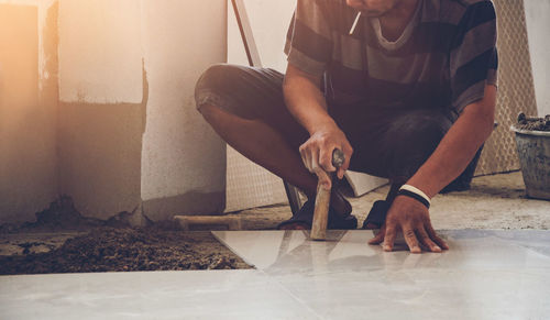 Low section of man sitting on floor at home