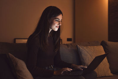 Young woman using laptop at home
