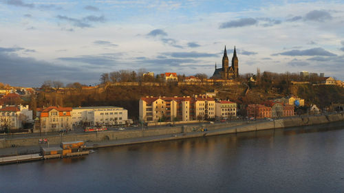 River amidst buildings in city against sky