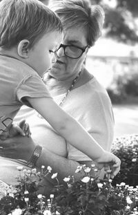 Senior woman with grandson picking flowers in yard