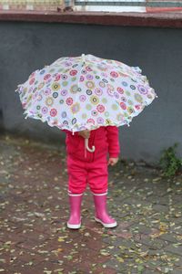 Low section of woman standing on street during rainy season