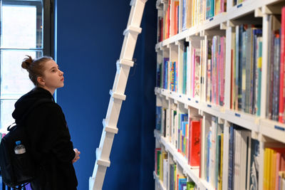 Rear view of man standing in library