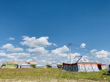 Traditional windmill on field against blue sky