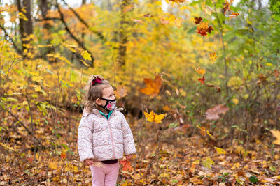 Low section of woman standing on leaves during autumn