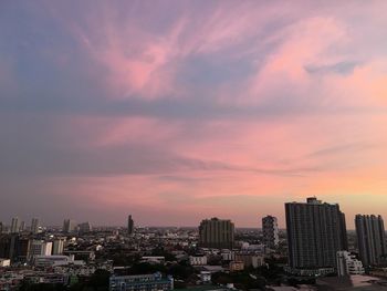 Modern buildings against sky during sunset