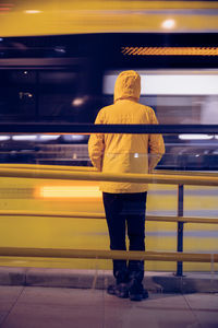 Rear view of man standing at railroad station