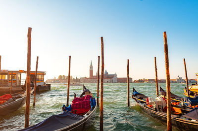 Boats in sea against clear blue sky