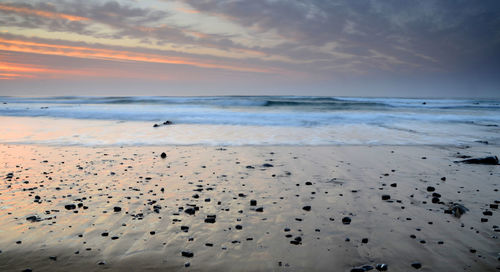 Scenic view of beach against sky during sunset