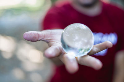 Midsection of man holding crystal ball