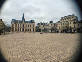 Buildings against cloudy sky
