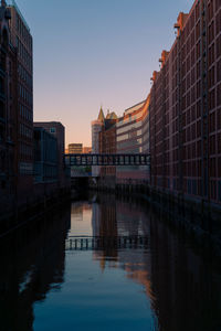 Reflection of buildings in city at sunset