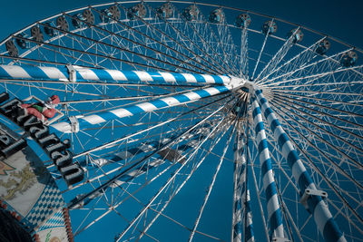 Low angle view of ferris wheel against blue sky